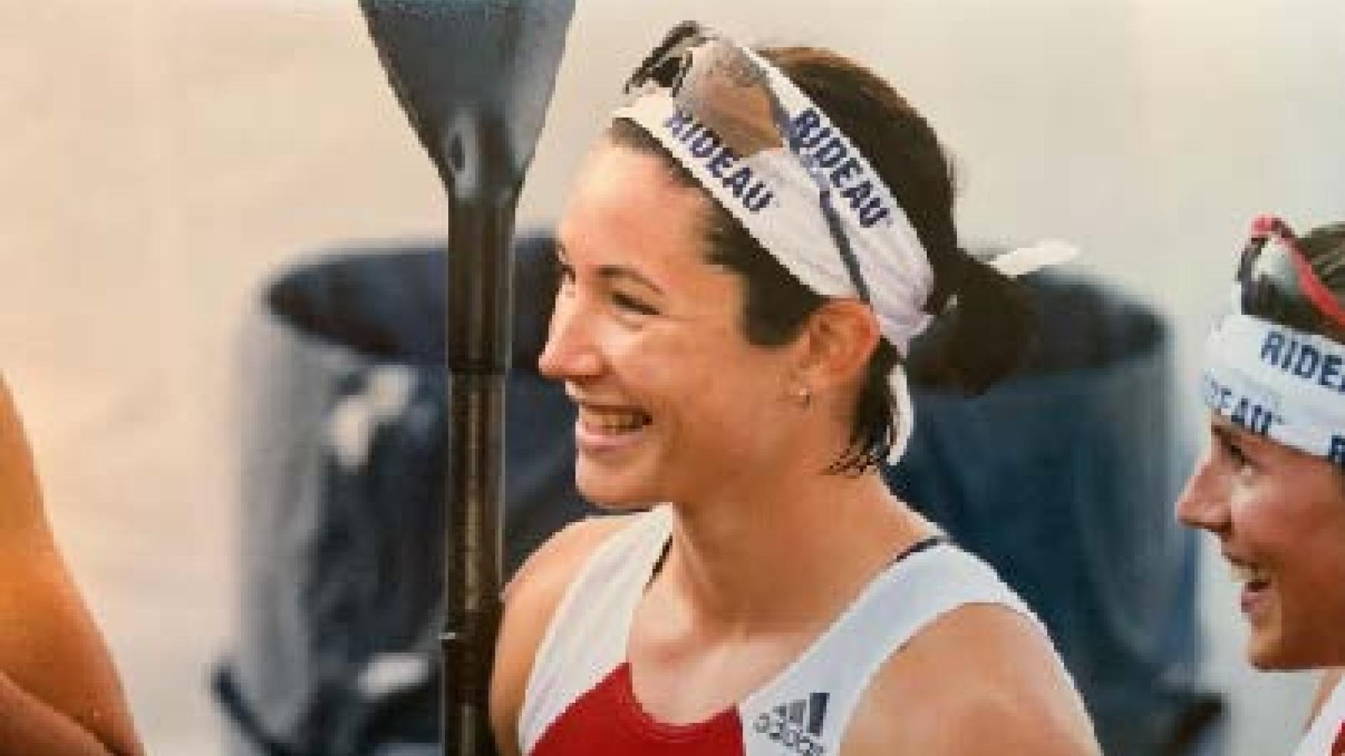 Sara Hopkins smiles as she stands with her paddle.